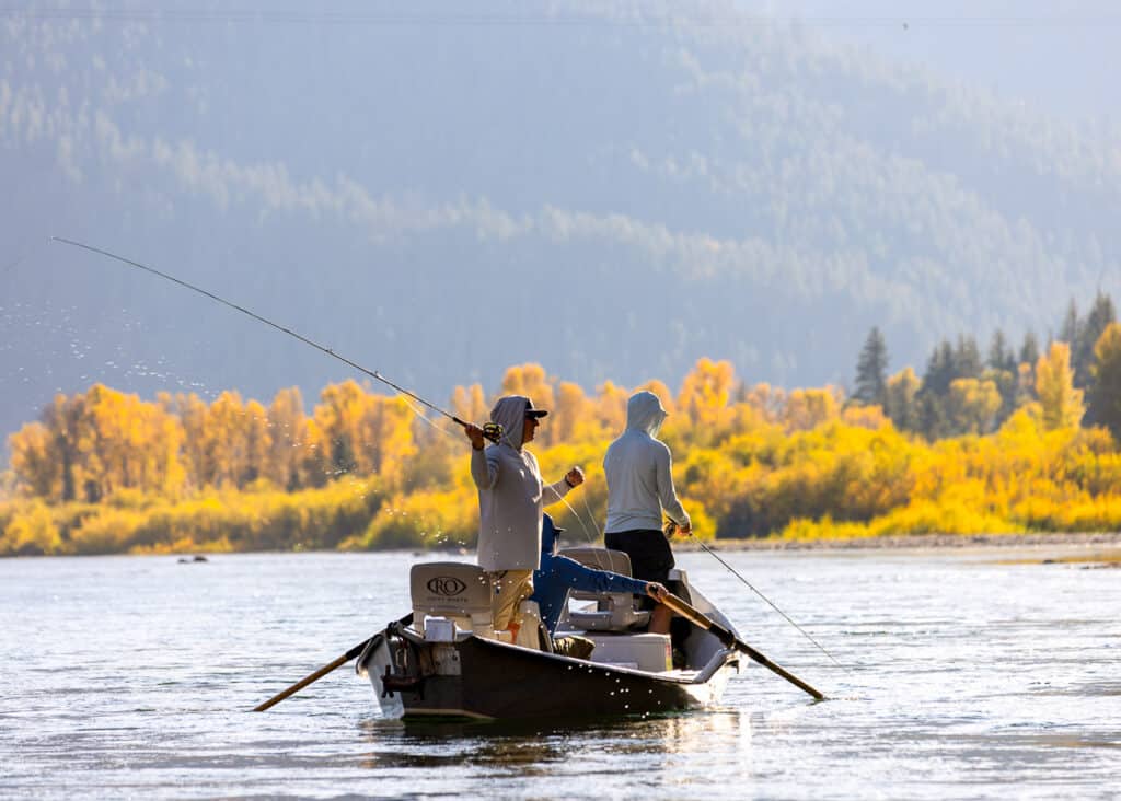 Men fishing on a lake wearing breathable sun hoodies